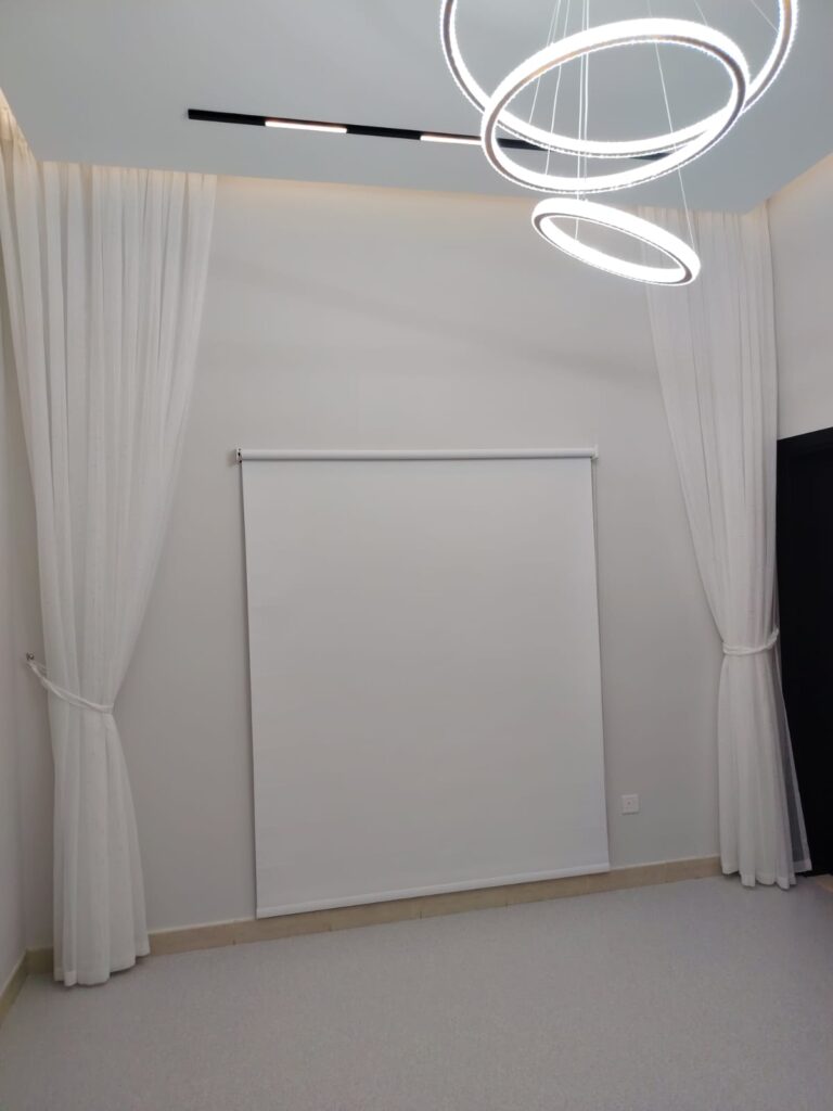 Blackout roller blind installed in a modern Dubai bedroom blocking sunlight completely
