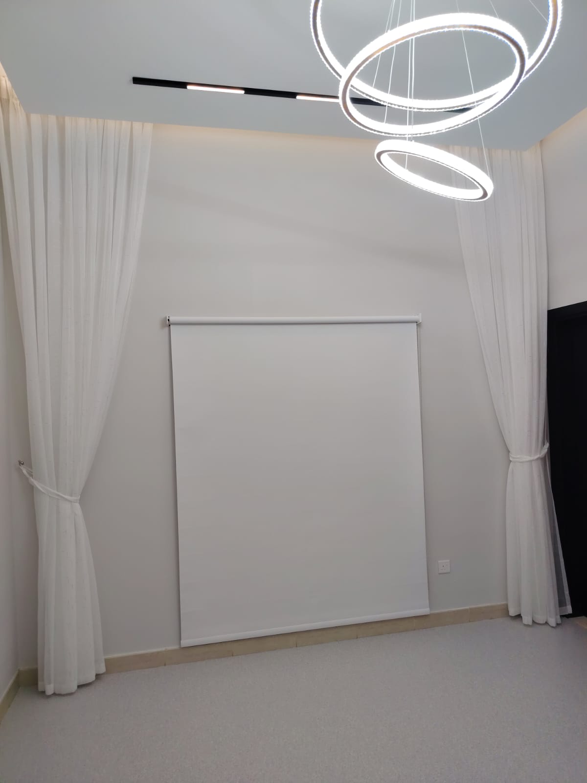 Blackout roller blind installed in a modern Dubai bedroom blocking sunlight completely