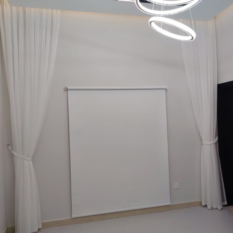 Blackout roller blind installed in a modern Dubai bedroom blocking sunlight completely